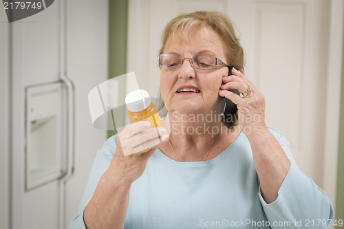 Image of Senior Adult Woman on Cell Phone Holding Prescription Bottle