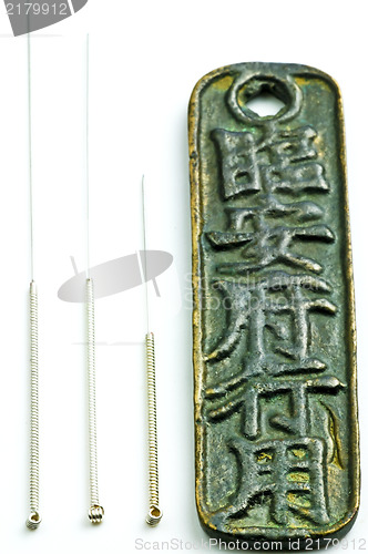 Image of acupuncture needles on chinese coin