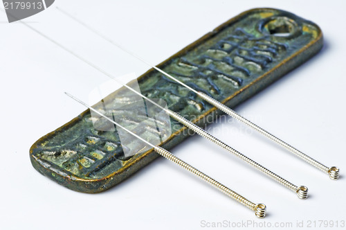 Image of acupuncture needles on chinese coin