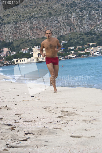 Image of Man Running Along Beach