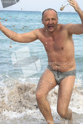 Image of Portrait of man with spashes in the sea