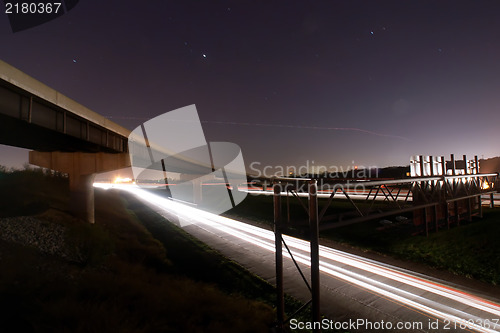 Image of traffic light trails under bridge