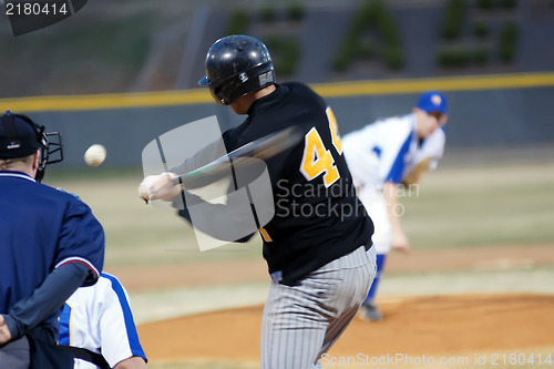 Image of A batter about to hit a pitch during a baseball game.