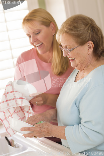 Image of Senior Adult Woman and Young Daughter Talking in Kitchen