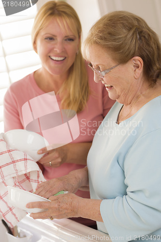 Image of Senior Adult Woman and Young Daughter Talking in Kitchen