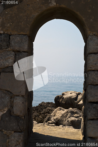 Image of old arch with sea and rocks in Cefalu