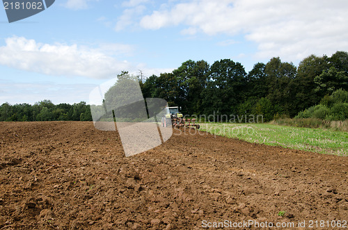 Image of tractor plowing agricultural field summer 