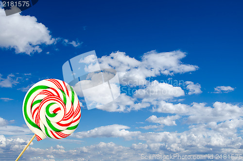 Image of Single sugar lollipop in white green and red on background of sk