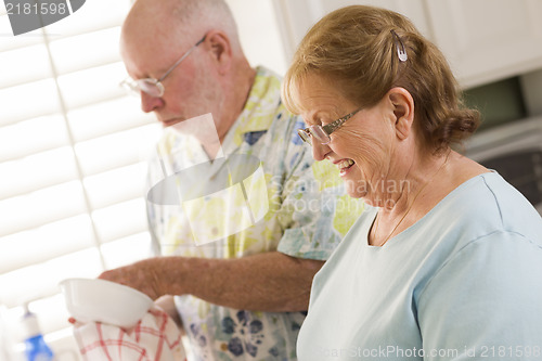 Image of Senior Adult Couple Washing Dishes Together Inside Kitchen