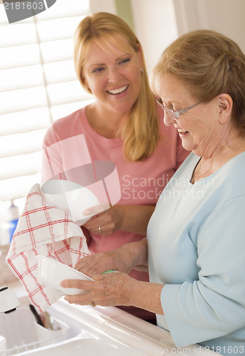 Image of Senior Adult Woman and Young Daughter Talking in Kitchen