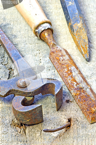 Image of old rusty pliers with nail