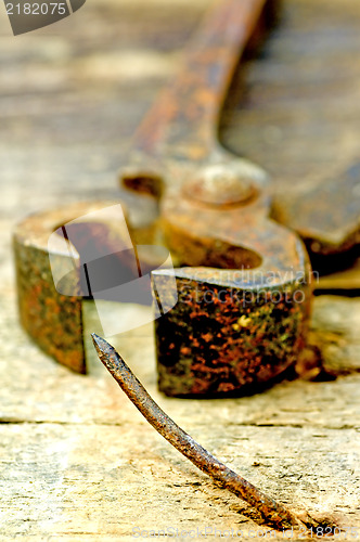 Image of old rusty pliers with nail