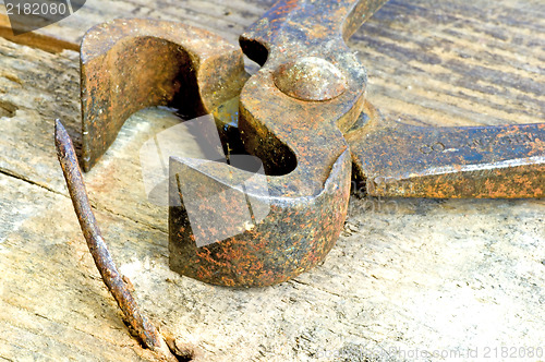 Image of old rusty pliers with nail