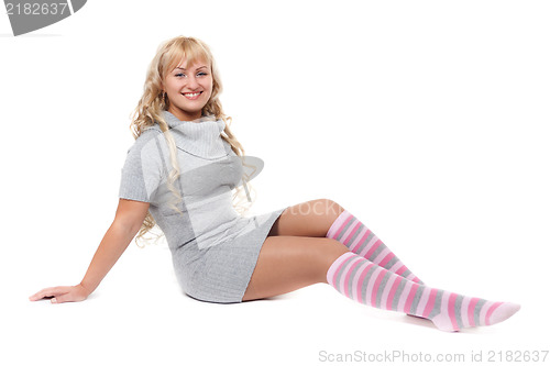 Image of Young beautiful blonde in a striped socks sits on the floor in t