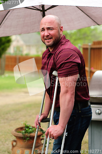 Image of Man on crutches looking at camera