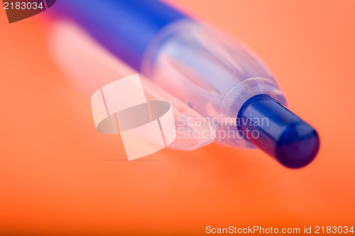 Image of photo of a blue pen on orange notebook