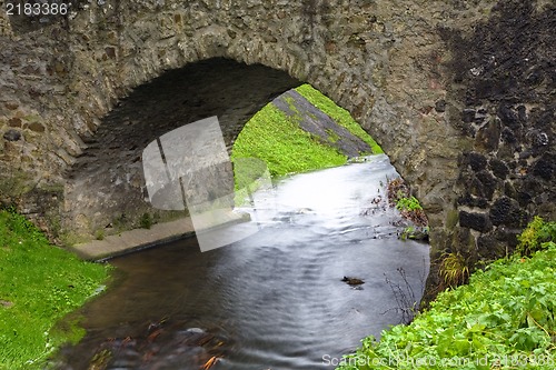 Image of Old stone bridge over a small river in spring time