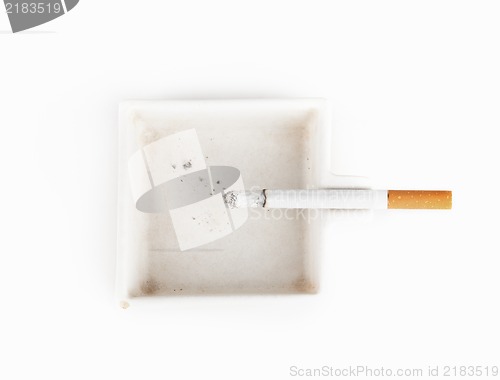Image of A burning cigarette in a white ashtray studio isolated on white