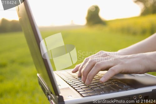 Image of Typing on a laptop outside