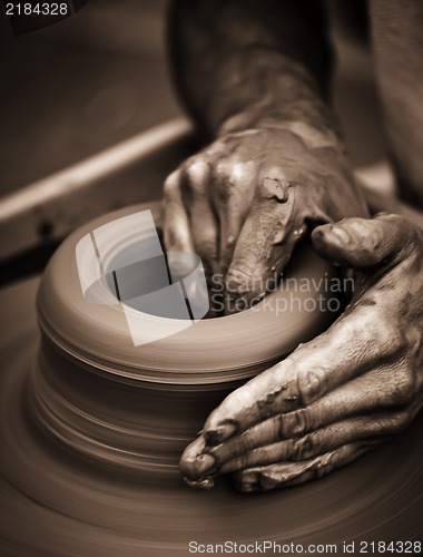 Image of Hands working on pottery wheel
