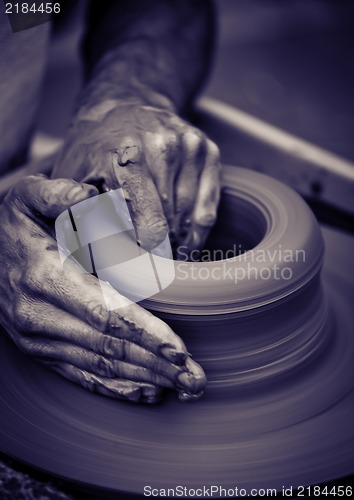 Image of Old man hands working on pottery wheel