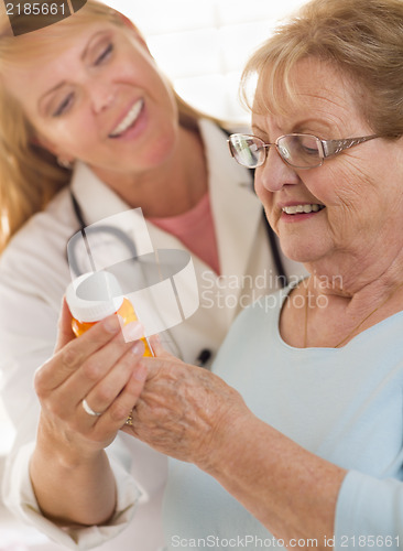 Image of Female Doctor or Nurse Explaining Prescription to Senior Adult W