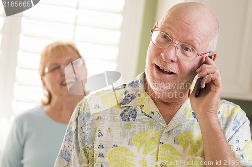 Image of Senior Adult Husband on Cell Phone with Wife Behind