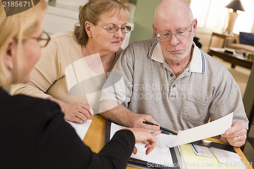 Image of Senior Adult Couple Going Over Papers in Their Home with Agent