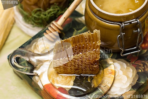 Image of Honey in pot, honeycomb and stick