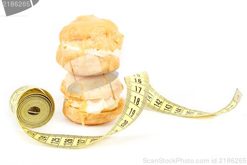 Image of concept of slimming, caramel cakes with measuring tape