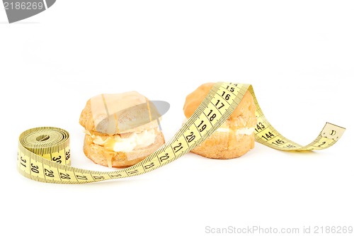 Image of concept of slimming, caramel cakes with measuring tape