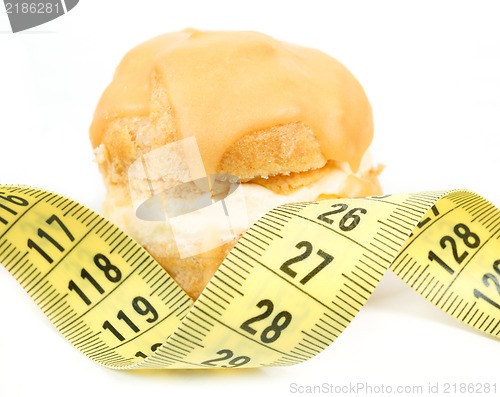 Image of concept of slimming, caramel cake with measuring tape