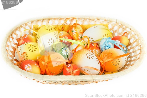 Image of painted easter eggs with ribbon in basket on white