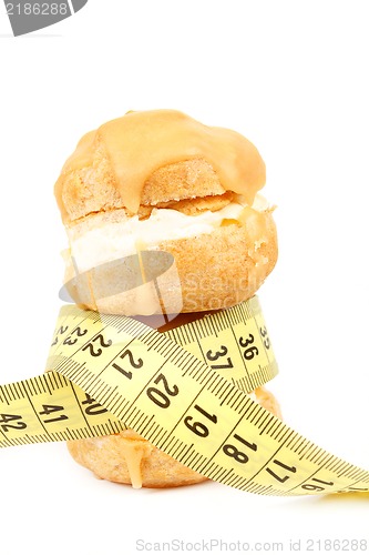 Image of concept of slimming, caramel cakes with measuring tape