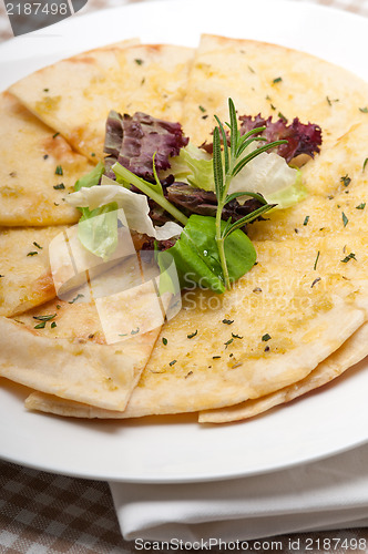 Image of garlic pita bread pizza with salad on top