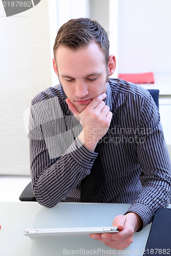 Image of Man concentrating as he reads his tablet screen