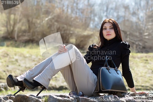 Image of Brunette sitting on the rock