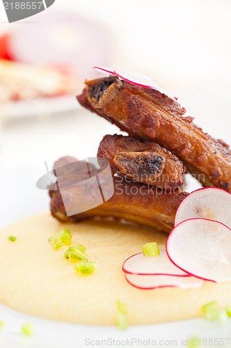 Image of pork ribbs on polenta corn cream bed