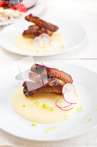 Image of pork ribbs on polenta corn cream bed