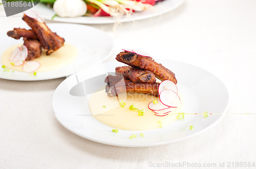 Image of pork ribbs on polenta corn cream bed