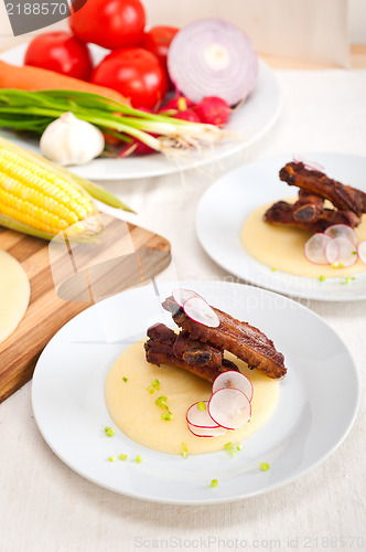 Image of pork ribbs on polenta corn cream bed