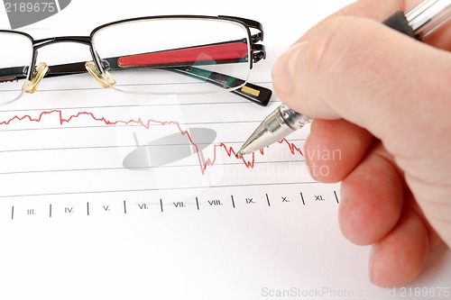 Image of men analyzing business graph with glasses in the background