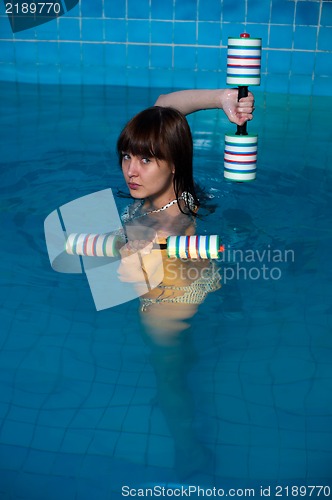 Image of Attractive girl trains in aqua aerobics