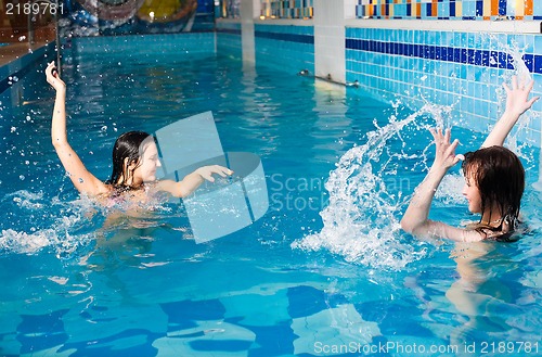 Image of Attractive girls relaxing in swimming pool