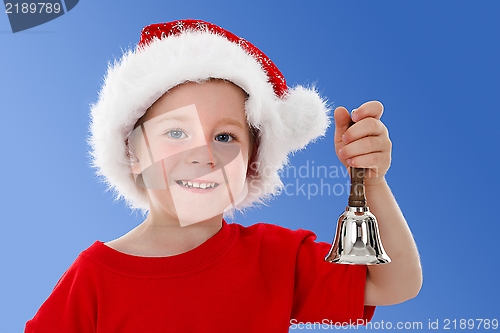 Image of Happy child ringing bell on blue