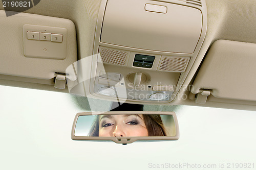 Image of woman looks on the rear-view mirror