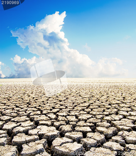 Image of land with dry cracked ground under blue sky