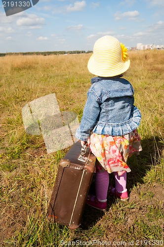 Image of lonely girl with suitcase. Back view