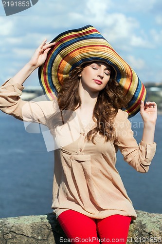 Image of Young brunette in colorful hat