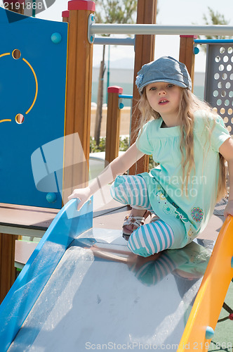 Image of Little girl in denim peaky cap playing